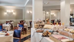 un restaurante con mesas con comida. en Hotel Da Vinci, en Montecatini Terme