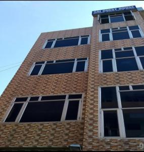 a tall brick building with many windows on it at Sai Guest House in Pathānkot