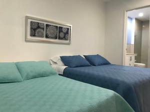 dos camas sentadas una al lado de la otra en una habitación en Morros Suites Apartamentos, en Cartagena de Indias