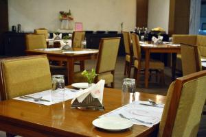 a wooden table with plates and napkins on it at Hotel Sree Annamalaiyar Park in Tirunelveli
