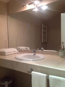 baño con lavabo y espejo grande en Galican Casa Rural en Moriscos