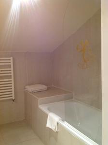 a white bathroom with a tub and a towel at Galican Casa Rural in Moriscos