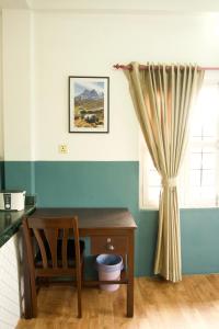 um quarto com uma mesa e uma janela com uma secretária em Hope Guest House em Pokhara