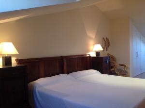 a bedroom with a white bed with two lamps at Galican Casa Rural in Moriscos