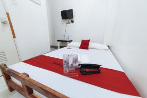 1 dormitorio con 1 cama con manta roja y blanca en RedDoorz @ Plaza Jaro Iloilo, en Iloilo City
