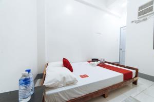a bedroom with a bed and a bottle of water at RedDoorz @ Plaza Jaro Iloilo in Iloilo City