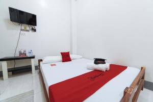 a bedroom with a bed with a red and white blanket at RedDoorz @ Plaza Jaro Iloilo in Iloilo City