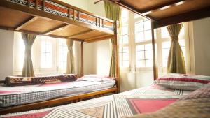 um quarto com 2 beliches e uma janela em Hope Guest House em Pokhara