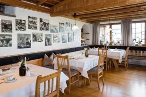 restauracja ze stołami i krzesłami oraz obrazami na ścianie w obiekcie Garni Zatzerhof w mieście Castelrotto