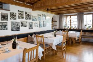 een restaurant met tafels en stoelen en foto's aan de muur bij Garni Zatzerhof in Castelrotto