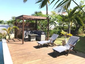 a wooden deck with chairs and a gazebo at Les Porcelaines in La Saline les Bains