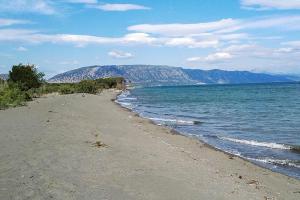 une plage avec l'océan et les montagnes en arrière-plan dans l'établissement Airen Hotel Velipoje, à Velipojë