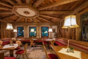 ein Restaurant mit Holzdecken, Tischen und Stühlen in der Unterkunft Hotel Christoph in Olang