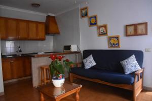 - un salon avec un canapé bleu et une table dans l'établissement Apartamento Veronica, à Puerto de Mogán