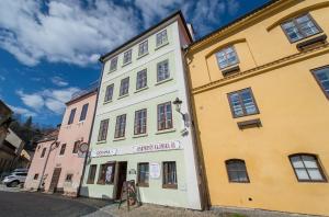 a white and yellow building on a street at Apartments Kajovska 63 in Český Krumlov