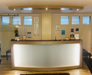 a large white counter in a room with chairs at Designhotel Im Südfeld in Kamen