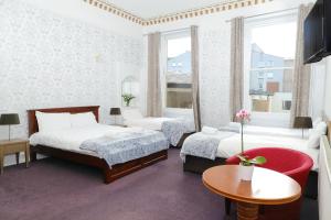 Habitación de hotel con 2 camas y mesa en Park View House, en Edimburgo