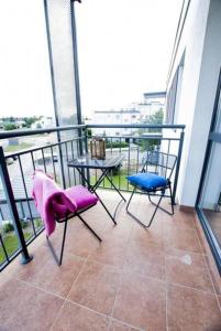 - un balcon avec deux chaises et une table dans un bâtiment dans l'établissement Apartament Słoneczny, à Uniejów