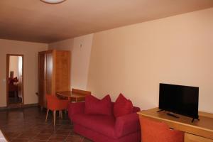 sala de estar con sofá rojo y TV en Rooms Cristian, en Deva 9 fotos más
