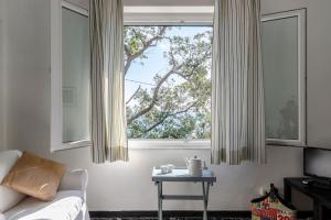 a bedroom with a bed and a window with a table at JOIVY Sea View Flat with Balcony, Cinque Terre in Monterosso al Mare