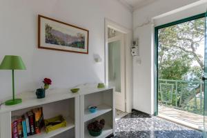 a living room with a book shelf and a window at JOIVY Sea View Flat with Balcony, Cinque Terre in Monterosso al Mare