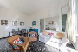 a living room with a white couch and chairs at JOIVY Sea View Flat with Balcony, Cinque Terre in Monterosso al Mare