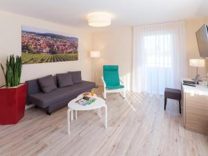 ein Wohnzimmer mit einem Sofa und einem Tisch in der Unterkunft Hotel Berkheimer Hof in Esslingen