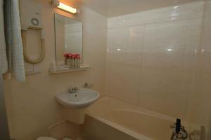 a white bathroom with a sink and a bath tub at Hôtel Restaurant Maison Blanche in Rungis +27 photos
