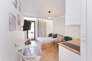 mały apartament z łóżkiem i stołem oraz kuchnią w obiekcie YOURAPART Chmielna Park w Gdańsku