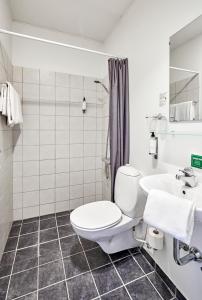 
a bathroom with a toilet, sink, and bathtub at Zleep Hotel Kolding in Kolding
