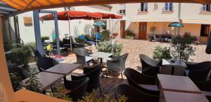 a patio with tables and chairs and an umbrella at Ô Spa Champenois in Écueil