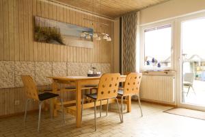comedor con mesa de madera y sillas en Apartment Muggensturm am Badesee en Muggensturm