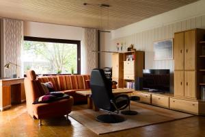 a living room with a couch and a television at Apartment Muggensturm am Badesee in Muggensturm