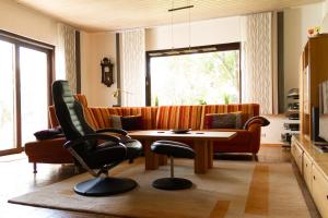 sala de estar con sofá, mesa y sillas en Apartment Muggensturm am Badesee en Muggensturm