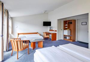 
a hotel room with a bed, table and chairs at Zleep Hotel Kolding in Kolding

