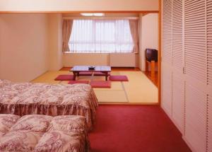 1 dormitorio con cama, mesa y ventana en Hotel Chalet Yuzawa Ginsui, en Yuzawa