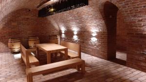 Pokój z dwoma stołami i ławkami oraz ceglaną ścianą w obiekcie Penzion Čáp w mieście Mikulov