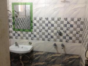 ein Badezimmer mit Waschbecken und Spiegel in der Unterkunft Sai Guest House in Pathankot