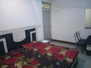 ein Schlafzimmer mit einem Bett mit roten Rosen darauf in der Unterkunft Sai Guest House in Pathankot