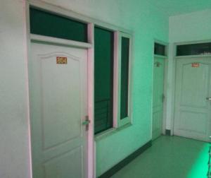 Habitación con 2 puertas blancas y paredes verdes. en Sai Guest House, en Pathankot