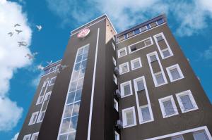 a tall building with a clock on the side of it at Antwo-Hotel in Kharkiv