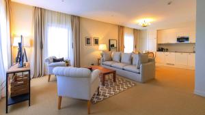 sala de estar con sofá y 2 sillas en Appartements Chais Monnet, en Cognac