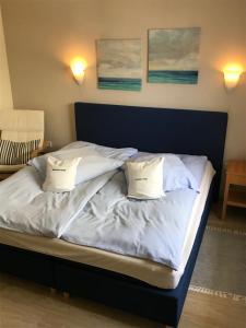 Una cama con dos almohadas encima. en Teutonia Hotel en Horn-Bad Meinberg