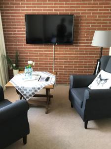 uma sala de estar com uma mesa e uma televisão numa parede de tijolos em Teutonia Hotel em Horn-Bad Meinberg