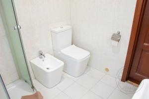 a white bathroom with a toilet and a sink at Antwo-Hotel in Kharkiv