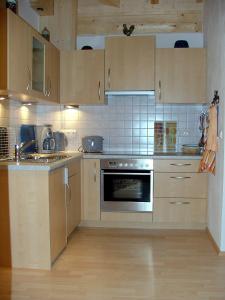 uma cozinha com armários de madeira e um forno em Haus Bergkristall em Bad Hindelang