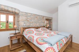 Bett in einem Zimmer mit einer Steinmauer in der Unterkunft Villa Nadia in Dobrinj + 50 Fotos