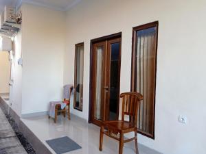a room with two chairs and two windows at Happy Penida Hostel in Nusa Penida