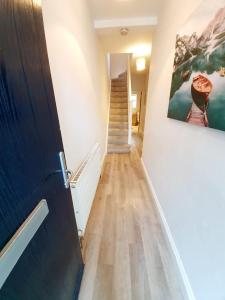 a hallway with a staircase and a painting on the wall at Beautiful 3 Bedroom House at the Sea Front - Amazing Location in Southend-on-Sea