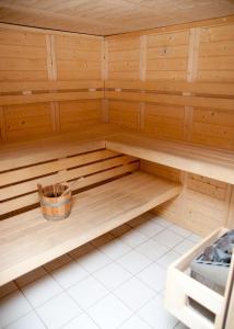 a wooden sauna with a bucket in the middle at travelski home select - Résidence Les Hauts de Valmeinier 4 stars in Valmeinier